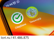 Adygea, Russia - September 13, 2023: icons of sberbank and tinkoff mobile banking applications on the smartphone screen. Редакционное фото, фотограф Андрей С / Фотобанк Лори