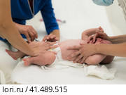 Baby beeing vaccinated by pediatrician in presence of his mother. Preventive vaccination against Diphtheria, whooping cough, tetanus, hepatitis, haemophilus influenzae, pneumococcus, poliomyelitis. Стоковое фото, фотограф Matej Kastelic / Фотобанк Лори