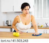 Young Chilean woman wiping dust from kitchen table. Стоковое фото, фотограф Яков Филимонов / Фотобанк Лори