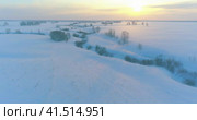 Aerial view of cold arctic field landscape, trees with frost snow, ice river and sun rays over horizon. Extreme low temperature weather. Стоковое видео, видеограф Александр Маркин / Фотобанк Лори