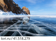 Beautiful winter landscape of frozen Baikal Lake on February. View of famous natural landmark of Olkhon Island - Khoboy Cape or Deva Rock on background of blue sky. Winter travel and outdoor recreation. Стоковое фото, фотограф Виктория Катьянова / Фотобанк Лори