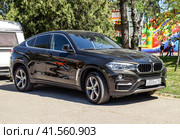 Black BMW X6 is parked in the park. A sports car of a premium cl (2017 год). Редакционное фото, фотограф Леонид Еремейчук / Фотобанк Лори