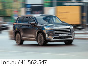 Fast moving black car Exeed VX on highway road. Overspeed in city concept. Chinese SUV on city road in motion, front side view. Редакционное фото, фотограф Константин Григорьев / Фотобанк Лори