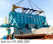 Raising the hopper car for unloading on a cargo ship. Lifting operations in the port. Стоковое фото, фотограф Леонид Еремейчук / Фотобанк Лори