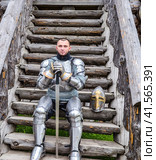 Knight in the armor on the wooden steps. Knightly armor and weapon. Стоковое фото, фотограф Леонид Еремейчук / Фотобанк Лори
