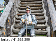 Knight in the armor on the wooden steps. Knightly armor and weapon. Стоковое фото, фотограф Леонид Еремейчук / Фотобанк Лори