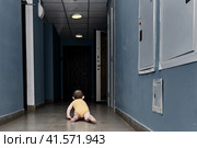 Toddler baby alone in a dark corridor. A lone child boy crawls in the darkness of the hall. Kid age one year. Стоковое фото, фотограф Андрей Журавлев / Фотобанк Лори