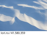 Beautiful winter background with snowy ground. Natural snow texture. Wind sculpted patterns on snow surface. Стоковое фото, фотограф Андрей Степанов / Фотобанк Лори