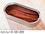 Tasty preserved anchovy fillet in oil on wooden surface, nobody. Стоковое фото, фотограф Яков Филимонов / Фотобанк Лори