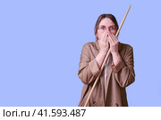 Scared woman teacher with pointer on studio blue background, copy space. Стоковое фото, фотограф Андрей Журавлев / Фотобанк Лори
