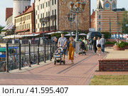 Kaliningrad, Russia - August 22 2022: People on the street in the summer day. A lot of people. They go for a walk on pedestrian street near the Pregol River. Modern lifestyle concept. Fishing village. Редакционное фото, фотограф YuryKara / Фотобанк Лори