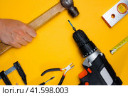 Male hand holds hummer. Top view of professional instrument. flat lay for construction tools concept. labor day or home diy. Стоковое фото, фотограф Константин Григорьев / Фотобанк Лори