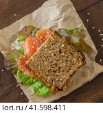 Redfish sandwich with with fresh salad laying on a rustic board. Стоковое фото, фотограф Воловодов Владимир / Фотобанк Лори
