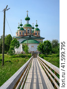 Wooden bridge leading to the Cathedral of Our Lady of Smolensk on an island among the woods in Olonets, Karelia, in summer (2023 год). Стоковое фото, фотограф Сергей Фролов / Фотобанк Лори