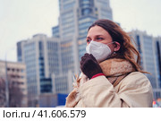 Portrait of adult woman with curly hair wearing ffp2 respirator on city street. Стоковое фото, фотограф Андрей Журавлев / Фотобанк Лори