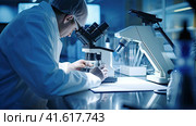 Microbiologist scientist looking through a microscope. Стоковое AI-изображение, AI-художник Кирилл Черезов / Фотобанк Лори
