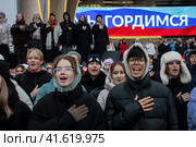 Молодые люди, члены Движение первых поют национальный гимн России во время репетиции музыкального спектакля "1000 первых", который должен состояться в День народного единства во время проведения выставки-форума Россия на ВДНХ в городе Москве, Россия (2023 год). Редакционное фото, фотограф Николай Винокуров / Фотобанк Лори