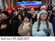 Молодые люди, члены Движение первых поют национальный гимн России во время репетиции музыкального спектакля "1000 первых", который должен состояться в День народного единства во время проведения выставки-форума Россия на ВДНХ в городе Москве, Россия (2023 год). Редакционное фото, фотограф Николай Винокуров / Фотобанк Лори