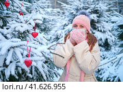 Sick woman coughs in a winter park with snowy trees with a face mask. New Year in a park with snowy trees. Стоковое фото, фотограф Андрей Журавлев / Фотобанк Лори