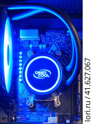 Computer parts inside pc with ice blue led liquid cooling - Moscow, Russia, December 23, 2020. Редакционное фото, фотограф Андрей Журавлев / Фотобанк Лори