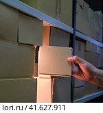Man takes a box from a warehouse at night. Стоковое фото, фотограф Андрей Журавлев / Фотобанк Лори