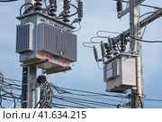 Electrical transformers on a power pole in Thailand, high voltage and power supply. Стоковое фото, фотограф Владимир Разгуляев / Фотобанк Лори