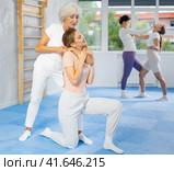 Elderly woman practicing chokehold on female rival during self-defense workout. Стоковое фото, фотограф Яков Филимонов / Фотобанк Лори