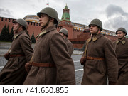 Люди в форме солдат и с оружием Великой Отечественной войны идут по Красной площади в центре города Москвы на фоне Московского кремля, Россия (2023 год). Редакционное фото, фотограф Николай Винокуров / Фотобанк Лори