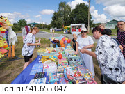 Клязьминский городок (Стародуб), Россия. Жители и гости рассматривают товары на импровизированной деревенской ярмарке во время праздника. (2023 год). Редакционное фото, фотограф Сергей Никифоров-Гордеев / Фотобанк Лори
