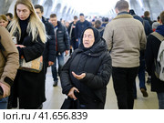 Blind woman with closed eyes begs in a crowd of people - Moscow, Russia, 12 13 2019. Редакционное фото, фотограф Андрей Журавлев / Фотобанк Лори
