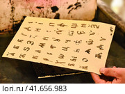 Cyrillic printed by the old method of typography. Man's hand holding a sheet with the Russian alphabet. Стоковое фото, фотограф Андрей Журавлев / Фотобанк Лори