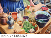 A woman prepares food for American immigrants from Europe. Table with dishes and food of the first American settlers. Retro life of pioneers in the Alaska, Klondike. Стоковое фото, фотограф Андрей Журавлев / Фотобанк Лори