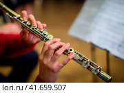 The girl is holding a large concert flute (in hands close-up). Professional musician at the rehearsal. A woman plays the transverse flute. Стоковое фото, фотограф Андрей Журавлев / Фотобанк Лори