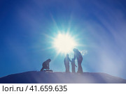 People ride a snow slide on a tuba and sled, silhouettes against the sun. Стоковое фото, фотограф Андрей Журавлев / Фотобанк Лори