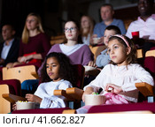 Preteen girl with african american friend watching movie in cinema. Стоковое фото, фотограф Яков Филимонов / Фотобанк Лори