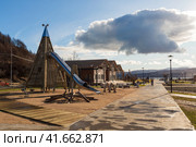 Этнопарк Дюкча, город Магадан, Магаданская область, Россия. Вид на пешеходные дорожки, детскую площадку и павильоны в парке. Вдалеке сопки на берег Охотского моря. Благоустройство на Дальнем Востоке России. Редакционное фото, фотограф Андрей Степанов / Фотобанк Лори