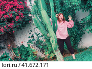 A woman imitates a zombie next to a large cactus. Стоковое фото, фотограф Андрей Журавлев / Фотобанк Лори