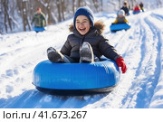 a Happy child rides a Tubing slide, Winter fun, Hobby recreation. Стоковое AI-изображение, AI-художник Ирина Ручушкина / Фотобанк Лори