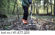 Serious boy with a metal detector examines the soil on a rocky trail on a summer evening. Стоковое видео, видеограф Igor Skripachev / Фотобанк Лори