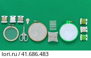 Video of supplies for hand embroidery - hoops with different types of canvas, embroidery needles, scissors and skeins of cotton threads on green background. Cross stitch. DIY concept. Copy space, flat lay, close-up, top view. Стоковое видео, видеограф Виктория Катьянова / Фотобанк Лори