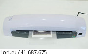 The plastic lamination machine spoils the document. The desktop laminator highlights the ultrasound result. Стоковое видео, видеограф Андрей Журавлев / Фотобанк Лори