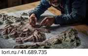 Geographer exploring the terrain on the model. Стоковое AI-изображение, AI-художник Кирилл Черезов / Фотобанк Лори
