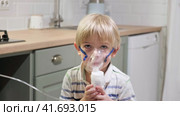 Sick Baby Boy with making Inhalation with a Mask on his Face sitting in Living Room at Home. Children Healing. Child Inhalation therapy with Compressor nebulizer. Inhaling fumes medication into lungs. Стоковое видео, видеограф Марина Демидюк / Фотобанк Лори
