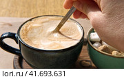 Person Mixing Cappuccino Foam in Blue Ceramic Cup on Wooden Cafe Table. Stirring Latte Thick Froth with Spoon. Trendy Authentic Modern Porcelain Set. Pottery Handmade Coffee Mug Served with Sugar Bowl. Стоковое видео, видеограф Марина Демидюк / Фотобанк Лори