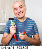Ordinary man posing with hammer in his hands. Стоковое фото, фотограф Татьяна Яцевич / Фотобанк Лори