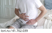 Stomach ache, man with abdominal pain suffering at home, health problems concept. Стоковое видео, видеограф Станислав Тарко / Фотобанк Лори