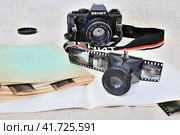 Архив фотолюбителя: зеркальный фотоаппарат "Зенит", пленки, хранящиеся в школьных тетрадях и лупа для просмотра пленки 35 мм (2023 год). Редакционное фото, фотограф Владимир Литвинов / Фотобанк Лори