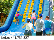Two young women climbing on inflatable castle with wooden sticks. Стоковое фото, фотограф Яков Филимонов / Фотобанк Лори