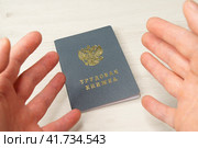 Трудовая книжка гражданина Российской Федерации с трудовым стажем на столе и мужские руки вскинутые в эмоциональном возгласе. Стоковое фото, фотограф Sergei Gorin / Фотобанк Лори
