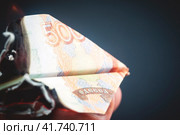 Rubles and dollars on fire in the form of paper airplanes, concessionary and sanctions (2020 год). Редакционное фото, фотограф Igor Skripachev / Фотобанк Лори